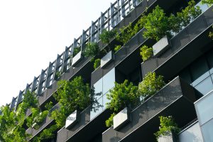Eco-friendly building in modern city. Sustainable glass office building with trees for reducing CO2.